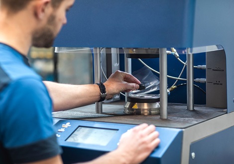 A man operates a machine to prepare for a AVK rubber test